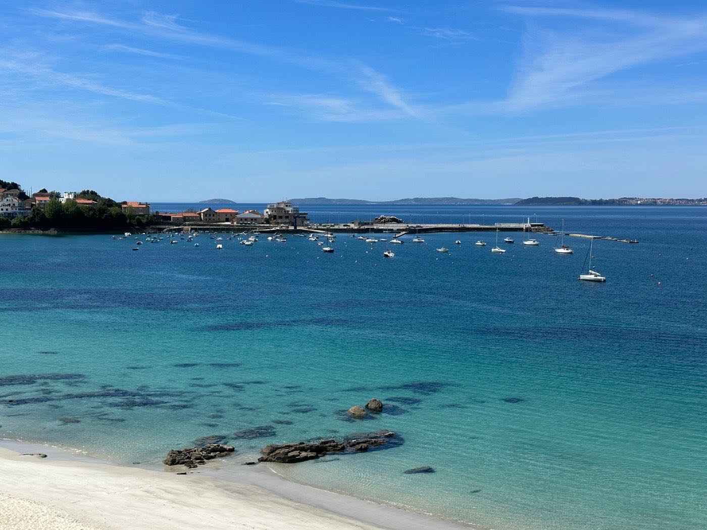 La ría de Vigo desde la costa, con barcos fondeados y casas al fondo